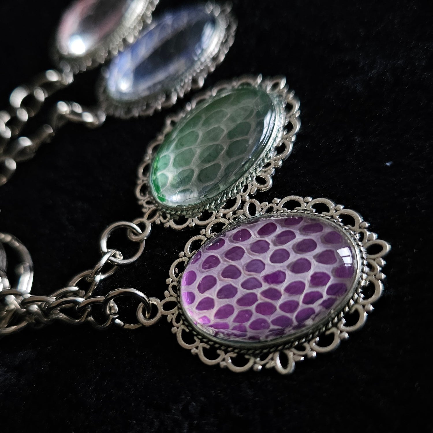 A silver, oval shaped keyring, made using snake shed. 